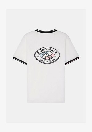 Chemise blanche à manches courtes avec col et manches rayés noirs, arborant un logo ovale "Eden Park French Flair 1987" avec des cravates roses et bleues.