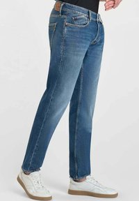 Jeans in denim di blu medio con una finitura leggermente sbiadita. Design a gamba dritta, cinque tasche e una patta in pelle marrone sulla vita posteriore.