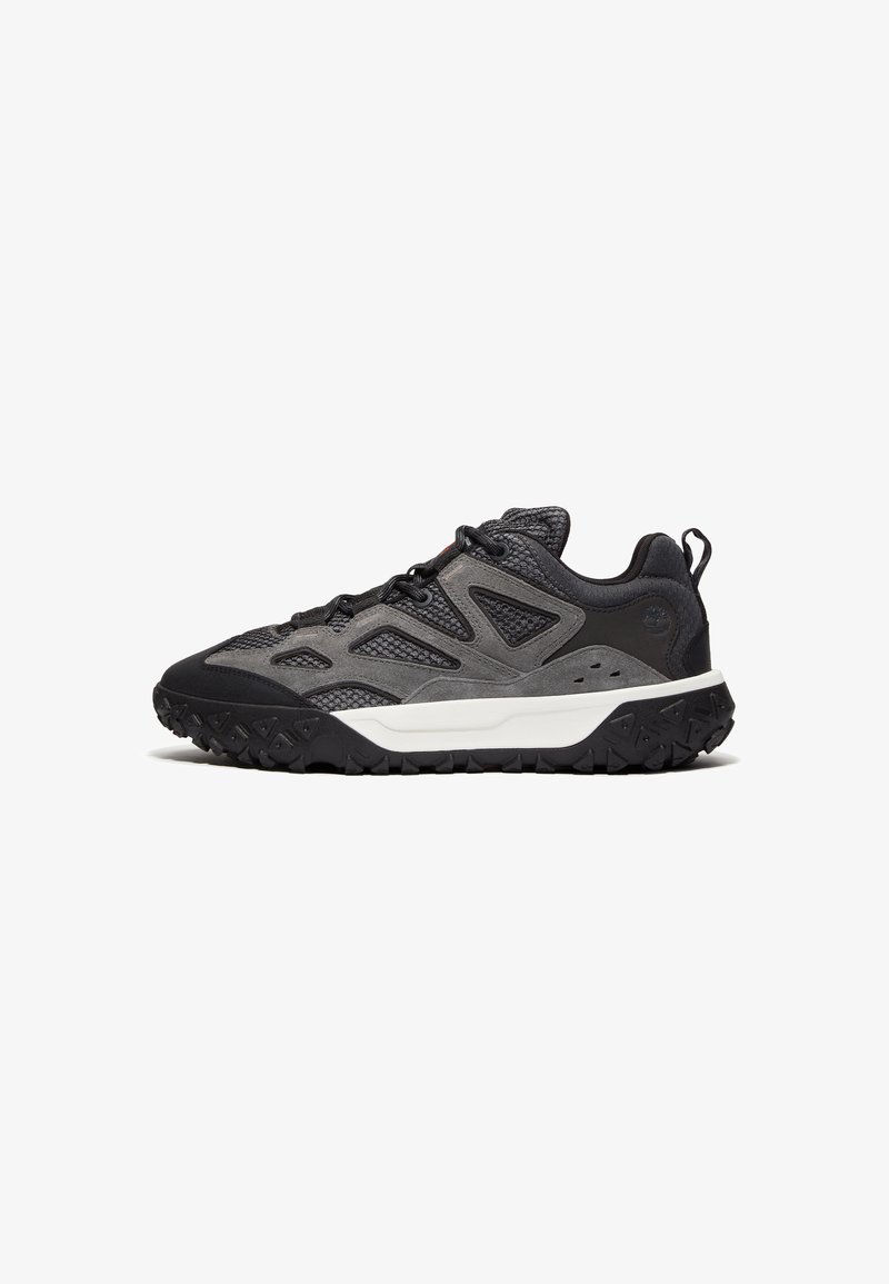 Dark gray hiking shoes with a textured mesh upper, rubber sole, and structured design. Features a white midsole and prominent tread pattern.
