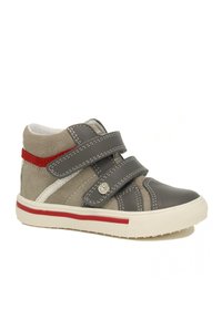 Grijze en beige hoge schoenen met klittenbandsluitingen, een witte zool, rode accenten en zichtbare stikdetails op leer en suede materialen.