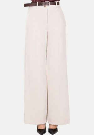 Pantaloni a gamba larga in tessuto beige testurizzato. Presentano una vita alta, pieghe cucite e una cintura marrone. Indossati con tacchi neri.
