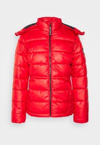 Röd puffjacka med hög krage, dragkedjestängning och quiltat mönster. Har svarta detaljer på axlarna och en logotypapplikation på ärmen.