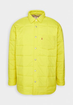 Geltonas siuvinėtas paltas su snapdiržiu, taškiniu apykakle, viena krūtine kišene ir prekės ženklo etikete. Lengvas, glotnus paviršius.