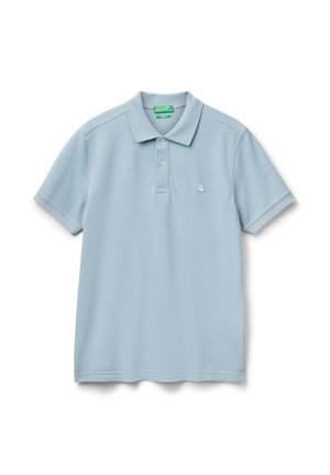 Světle modrá polokošile s krátkým rukávem, se zapínáním na knoflíky a malým vyšitým logem na levé hrudi, položená na bílé pozadí.