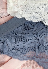 Spetstyger i vitt, blått och rosa. Invecklade blommönster och vågiga kanter. Mjuk textur och fin nätdetaljering.