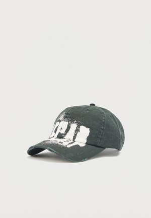 Gorra de béisbol verde oscuro con bordes desgastados y un diseño de salpicaduras de pintura blanca en el panel frontal y la visera.