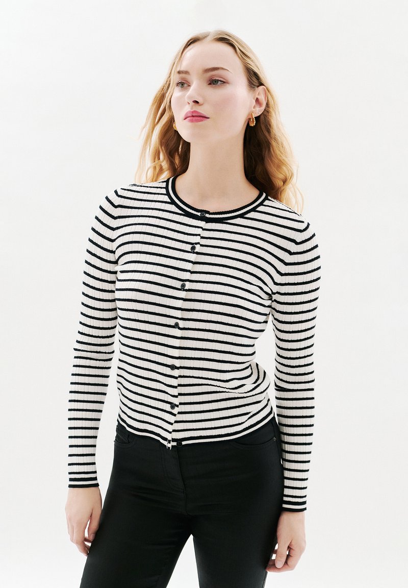 Black and white striped ribbed cardigan with long sleeves, round neckline, and button closure along the front. Soft fabric texture.