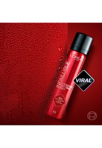 Bouteille rouge de L'Oréal Infaillible 3-Second Setting Mist avec bouchon noir sur une surface rouge mouillée avec des gouttelettes d'eau.