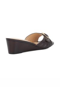 Brown leather wedge sandal with a curved design, open toe, and a decorative gold buckle on the strap. Textured upper and smooth interior.