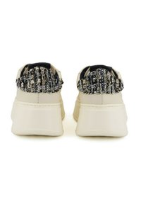 Sneakers bianchi con un tallone a motivo testurizzato blu scuro e crema. Materiale sintetico liscio, punta arrotondata e suola spessa per un'ammortizzazione ottimale.