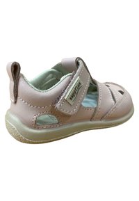 Sandalia de cuero rosa claro con cierre de Velcro, diseño abierto y perforaciones para la transpirabilidad. Suela de goma con detalles en tono marrón.