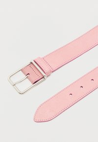 Ζώνη από ανοιχτό ροζ καστόρι με ασημένια ορθογώνια αγκράφα και πολλαπλές τρύπες ρύθμισης σε λευκό φόντο.