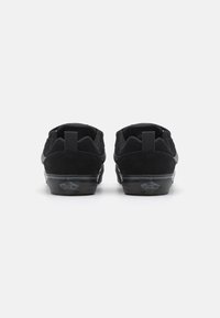 Baskets en suede noir avec une semelle en caoutchouc plate, un dessus texturé et des coutures contrastées. Comprend une languette au dos et un logo de marque au talon.
