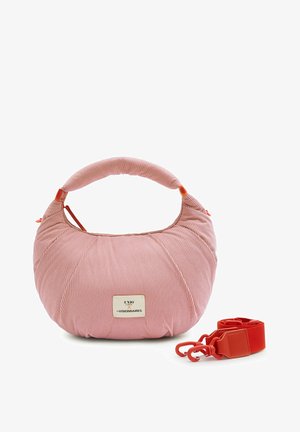 Pinkfarbene, gerippte Stoffhandtasche mit gepolstertem Griff und abnehmbarem roten Riemen, mit einem kleinen rechteckigen Etikett vorne.