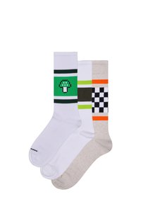 Tři páry ponožek do kotníků: bílé s zelenými houbami a pruhy, bílé se zelenými a tmavými pruhy, béžové s černobílými kostkami a oranžovými pruhy.