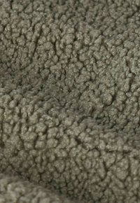 Olivgrüner, strukturierter Stoff mit einer samtigen, plüschigen Oberfläche, die ein konsistentes Muster kleiner, erhabener Schlaufen aufweist.