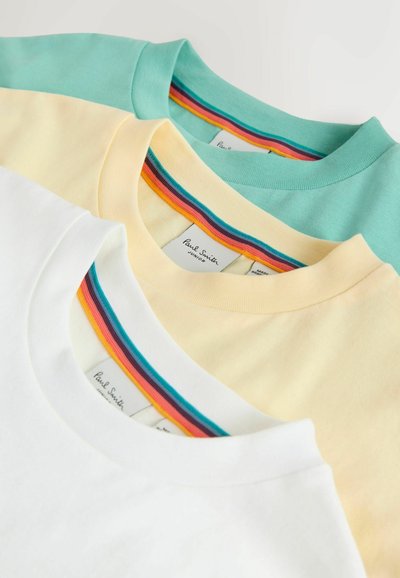 Tre foldede crewneck T-shirts i hvid, lys gul og mintgrøn, hver med flerfarvetstripet kant inde i halsåbningen.