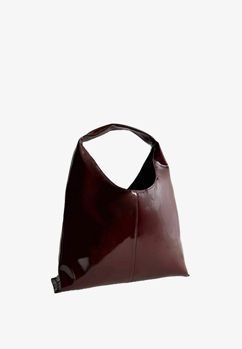 Maroon leren schoudertas met een slordig design, een brede opening en een gladde, glanzende textuur. Voorzien van een afgeronde handgreep.
