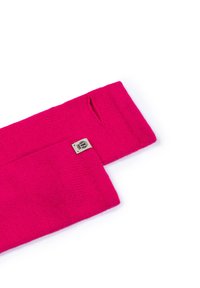 Fuchsia knitted scarf with a textured pattern, featuring a small label with a logo. Two ends are open for ease of wear.