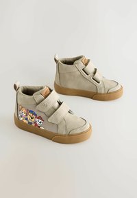 Beige High-Top-Schuhe mit zwei Klettverschlüssen, die ein buntes grafisches Motiv von Cartonhunden an der Seite und eine Gummisohle haben.