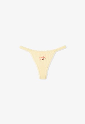 Tanga de color crema con encaje, bordado pequeño de sandía y texto "juicy lover" en rojo en el centro delantero.