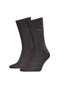 Calcetines grises hechos de un material suave y texturizado. Cuentan con puños acanalados y un pequeño logo en el costado. Diseño clásico de longitud estilo crew.