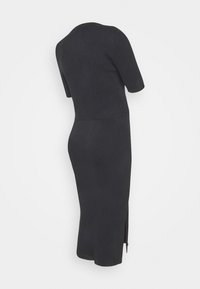 Mustat ribatut mekko lyhyillä hihoilla, istuva yläosa ja polven keskelle ulottuva pituus. Sisältää sivuaukot ja pyöreän kaula-aukon.