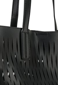 Zwarte tote bag met verticale snit-openingen en twee gestikte leren handvatten.