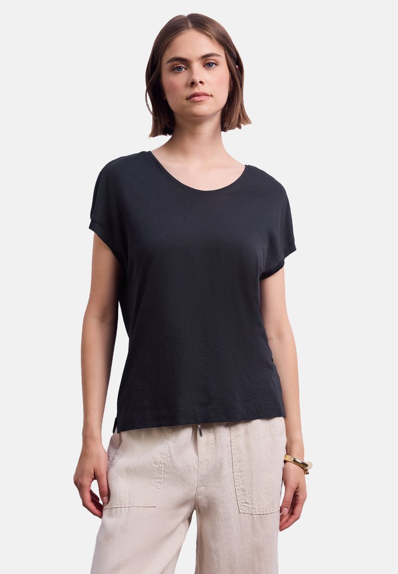 Černé tričko s krátkým rukávem a kulatým výstřihem vyrobené z měkké látky. Má volný střih a jemné boční rozparky na lemu.