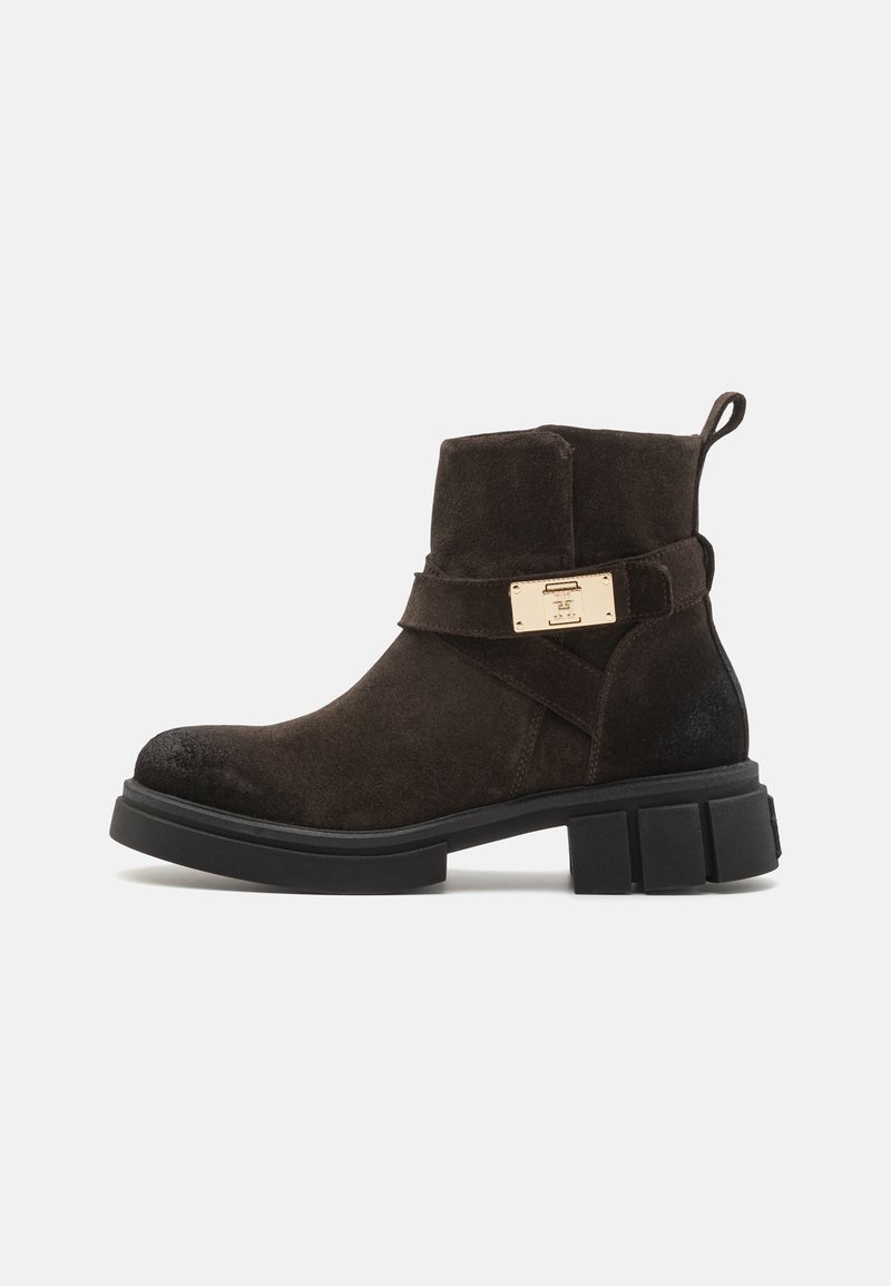 Brune semsket ankelstøvlette med en robust gummisål, som har en sidestraps og en hardwaredetalj i gulltone. Rektangulært design, teksturert overflate.