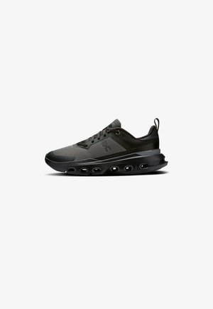 Men’s black athletic shoes with a textured mesh upper, padded collar, lace-up design, and a thick, cushioned sole featuring cut-outs.