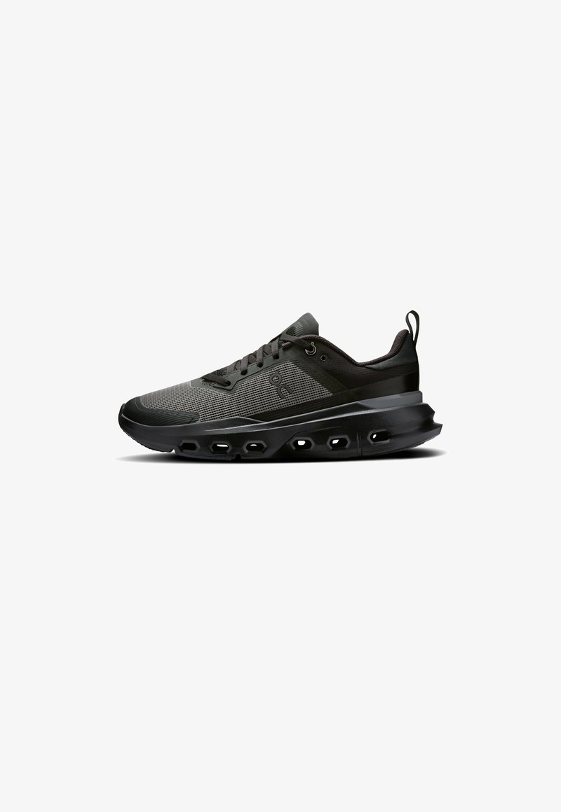 Schwarze Herren-Sportschuhe mit einem strukturierten Mesh-Obermaterial, gepolstertem Schaftrand, Schnürdesign und einer dicken, gepolsterten Sohle mit Ausschnitten.
