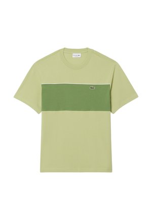 T-shirt col rond à manches courtes en vert clair avec une large bande horizontale vert foncé traversant la poitrine et un petit logo crocodile.