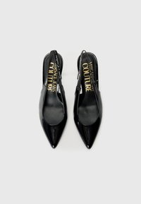 Black patent leather slingback heels with pointed toes. Features slip-on design and logo-embellished straps. Smooth texture.