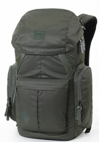 Mochila verde oscura hecha de nylon, con una solapa superior, múltiples bolsillos con cremallera y un panel trasero de malla texturizada para mayor soporte.