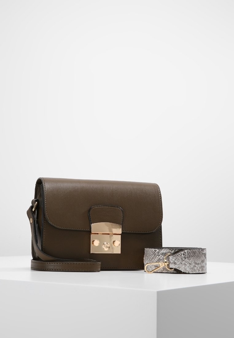 Brun læder crossbody-taske med en guldlås, der har en rektangulær form og en aftagelig rem med slangeskindsprint. Enkel, glat tekstur.