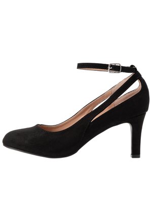 Schwarzer Wildleder-Pumps mit mittlerem Absatz, geschlossenem Zehenbereich, Knöchelriemen und silberner Schnalle, Seitenansicht auf weißem Hintergrund.