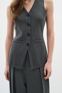 Gilet grigio senza maniche con scollatura a V, caratterizzato da quattro bottoni neri, due tasche frontali e una vestibilità sartoriale, realizzato in tessuto testurizzato.