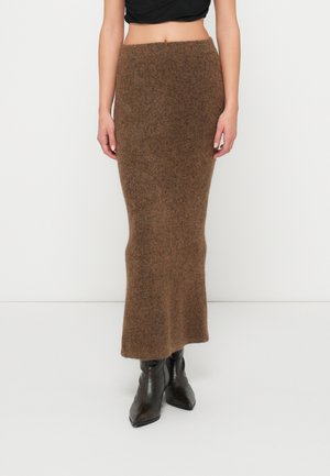 Jupe maxi en mélange de laine marron avec une taille ajustée, un design sans coutures et une légère évasée à l'ourlet. Associée à des bottines noires à bout pointu.