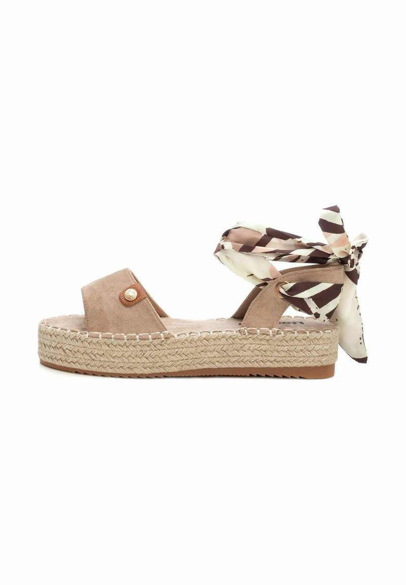 Sandalia de cuña abierta de ante en beige claro, que cuenta con una suela de yute trenzada, un botón decorativo y cintas de tela con estampado en el tobillo.