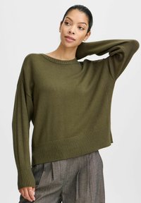 Olivgrüner, übergroßer Pullover mit geripptem Saum und Ärmeln, aus weichem Strickmaterial. Verfügt über einen Rundhalsausschnitt und eine lockere Passform.