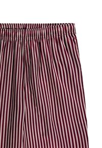 Randiga shorts i flera färger med en avslappnad passform, elastisk midja och ett mjukt, lätt tyg i burgundy och krämfärger.