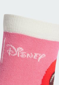 Calzini rosa con risvolto bianco, caratterizzati da un design di personaggi dei cartoni animati e testo. Realizzati in morbido materiale a maglia, mostrano una transizione di colore solido.