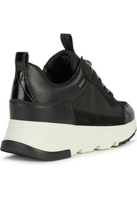 Sneaker nera realizzata in pelle e suede, con dettagli testurizzati, una suola intermedia bianca e una suola esterna in gomma nera.