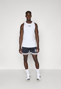 Hvit treningstopp med svart logo, kombinert med marineblå mesh shorts med lysegrå detaljer og New York-logo, brukt med hvite sneakers.