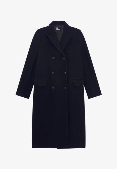 Marineblauwe dubbelgeknoopte jas van een wolmix, met grote knopen, reverskraag en twee voorzakken. Soepele textuur met een lange, rechte pasvorm.