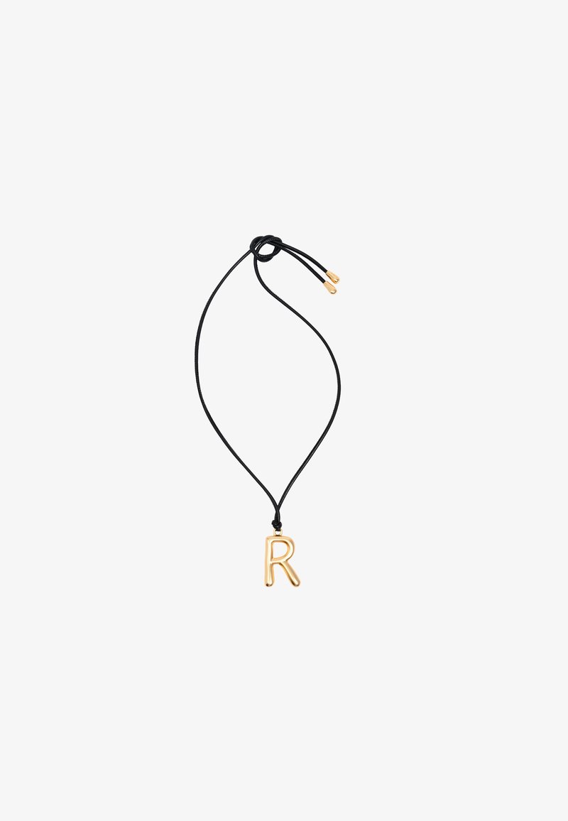 Gouden "R" hanger aan een zwarte koordketting, met een gladde afwerking en een verstelbare lengte met gouden accenten op de uiteinden van de koord.