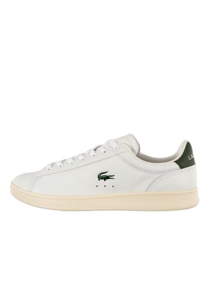 Sneaker in pelle bianca a taglio basso con suola beige, logo coccodrillo verde sul lato e linguetta del tallone verde scuro con scritta bianca.