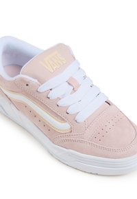 Vans Sneakers aus hellrosa Wildleder mit weißen Akzenten, die eine strukturierte Oberseite, weiße Schnürsenkel und eine durchbrochene Detailierung an der Zehenbox aufweisen.