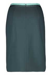 Mörk teal knälång kjol med en centrerad söm bak och ett midjeband som har en glittrig turkos rand ovanför en svart remsa.